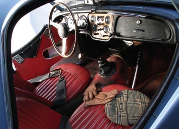 Originally blue leather, the interior was redone in red in the seventies. The Nardi wheel and chromed rollbar are other prominent interior add-ons.