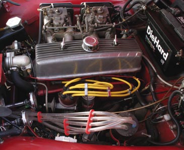 Dual Webers and a chromed header help hot-rod the 2.2L engine. Air lines for the 5- trumpet horn are also visible.
