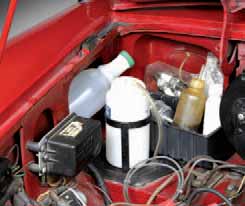 Fender-well storage: small items can be stashed behind an MGB’s windscreen washer bottle. Things like dashpot oil, spark plugs, fuel filter, small bottle of water, fan belt, and possibly odd tools will fit in there. Parts like a distributor and a water pump could be tie-wrapped by the MGB’s master cylinder, by the radiator support brackets, or by the absorption canisters.