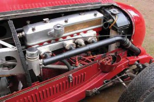 The MG 1100cc inline six-cylinder gets fed boost from a front-mounted supercharger. An intake tube travels back to the engine, pressurizing the three-port intake manifold.
