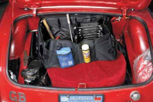 Moss’s Space Master cargo organizers are a versatile storage solution for British boots; they hold spare oil, a jack, flashlight, and more. The double-decker method is another approach: using a spare-tire-height toolbox and waferboard can create two-tiered storage.